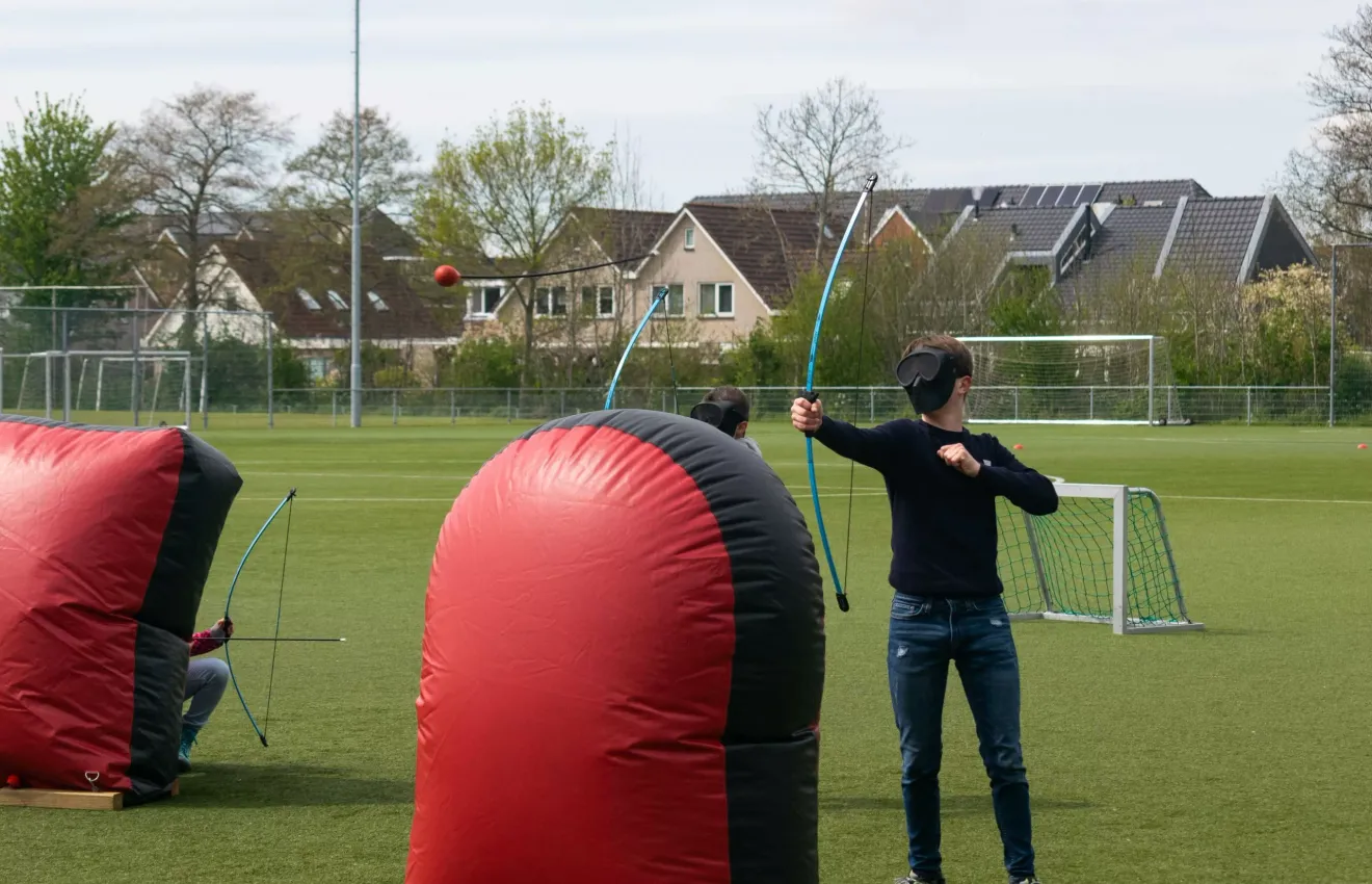 Archery tag huren voor twee kinderen op een sportveld met obstakels