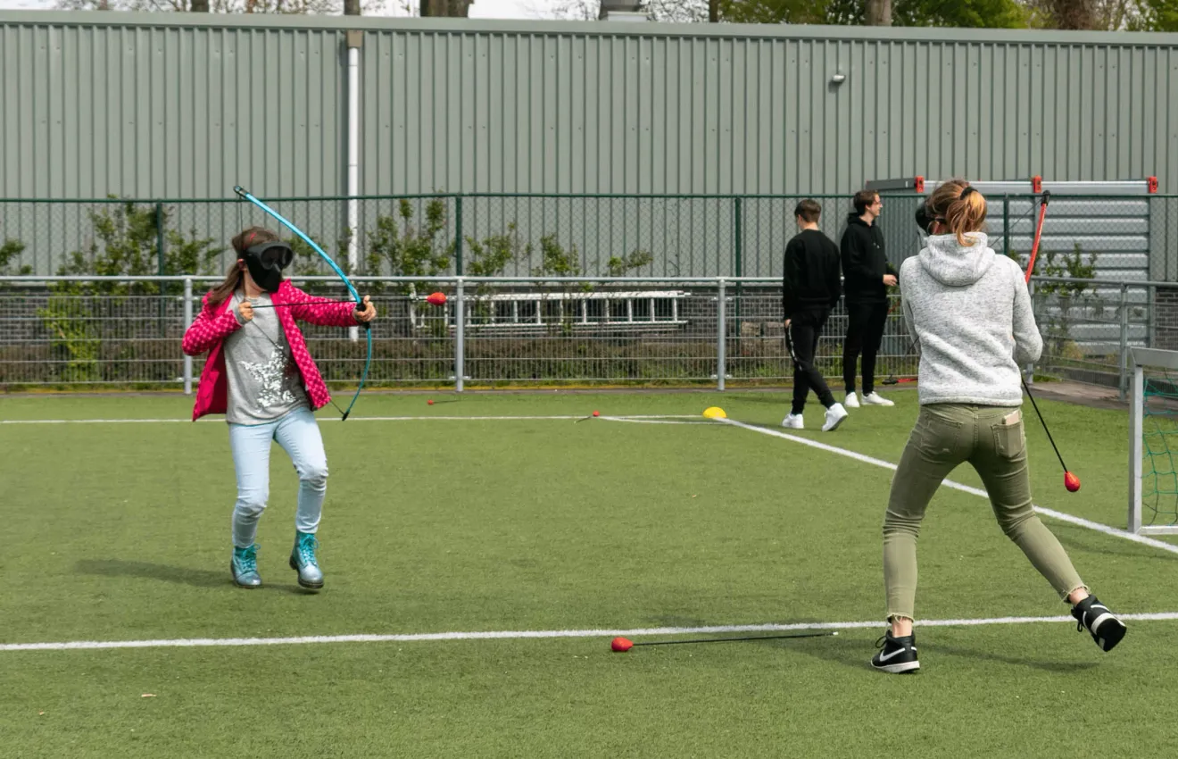 Twee mensen mikken op elkaar tijdens archery tag