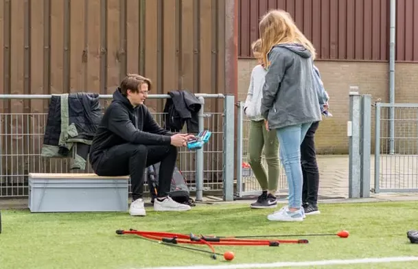 Een kinderfeestje met drie kinderen en een lasergun buiten op een veldje