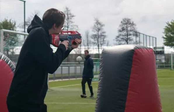 Lasergamen op een grasveld met obstakels en een lasergun