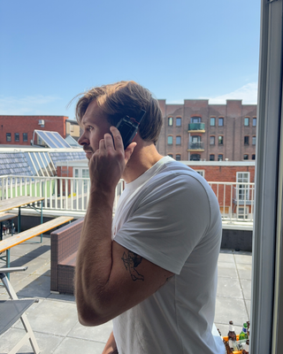 Een man met een gehuurde portofoon op het dak van zijn woning