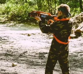 Een kind mikt met een lasergun in het bos