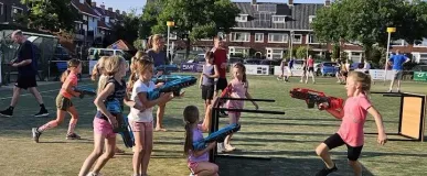 Een kinderfeestje waarbij kinderen laserguns dragen op een grasveld