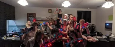 Een groep studenten die lasergame spullen op de studentenvereniging vasthouden
