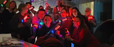 Een groep mensen die lasergame spullen op kantoor dragen