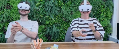 Collega's die samen een VR-bril gebruiken voor teambuilding
