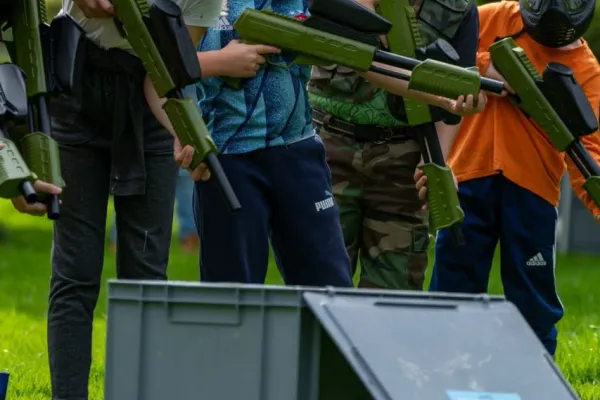 Vier kinderen leren de spelregels van paintball op een kinderfeestje