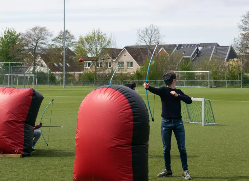 Archery tag huren voor twee kinderen op een sportveld met obstakels